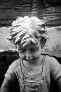 Child boy, Stone sculpture at water