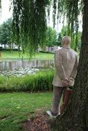 statue of a man near a tree in a park