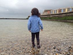 girl in a blue sweater on the beach
