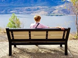 man sitting on a wooden bench