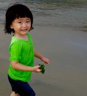 asian child on ocean beach