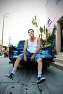 the guy sitting on the hood of the car