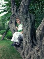 child Boy sitting on old Tree