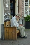 old man sitting on a wooden bench