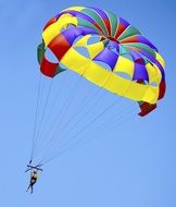 parachutist with a colored parachute in the blue sky