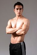 smiling muscular man posing in black shorts