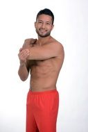 smiling muscular man posing in red shorts