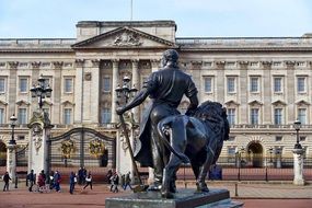 man with hammer and lion, bronze statue at Buckingham Palace facade, uk, London