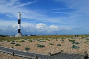 striped lighthouse on a sandy beach