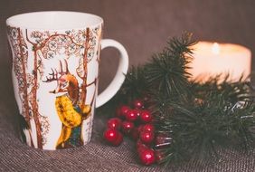 candle and pine branches and cup