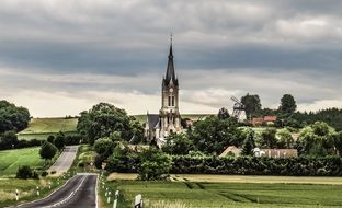 old church and windmill in countryside