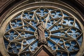 statue on the background of a stained-glass window