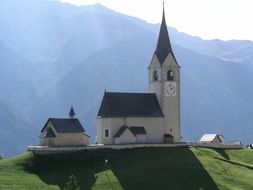 panoramic view of a village church in the mountains of switzerland