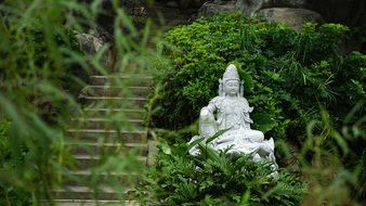 white buddha statue among greenery in the park