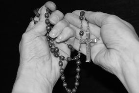 rosary with a cross in hand in black and white image