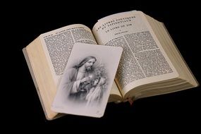 Open Bible and a postcard with the image of Christ