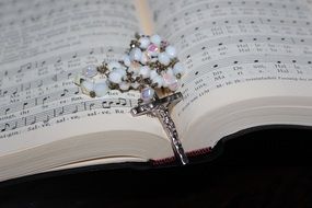 silver catholic cross on a prayer book