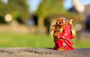 cheerful buddha as a small figure in the park