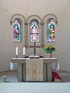 white altar with stained glass windows in the church