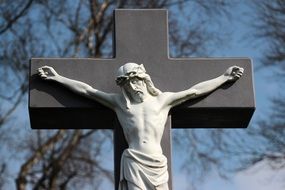 cross with a crucifix in a cemetery close-up on blurred background