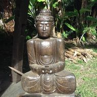 Buddha in lotus position like a stone statue in the garden