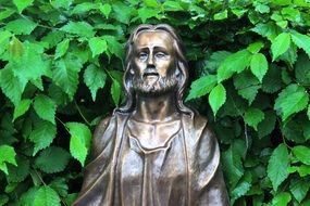 bronze statue of Christ in greenery