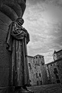 christian saint with cross, aged stone Sculpture