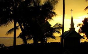 silhouette of a church against the backdrop of a tropical sunset in Hawaii