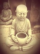 statue of a monk with a bowl in his hands
