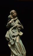 statue of mary with a child on a black background