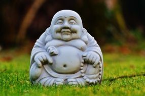 Buddha like a stone figure on green grass