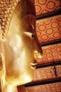 golden buddha in profile in the temple close-up