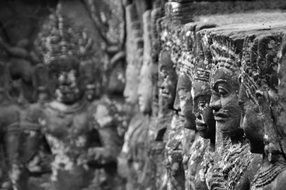 Black and white photo of a statue in a temple complex in Cambodia