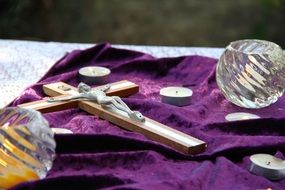 candles and cross with a crucifix on purple cloth