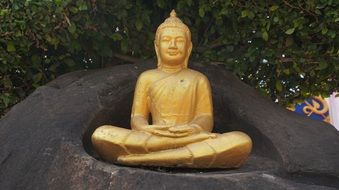 golden buddha statue on stone