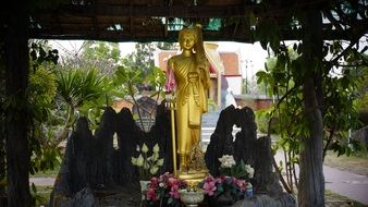 buddhist Holy Statue beneath shed in front of tmple, thailand