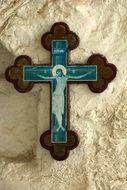 wooden cross with a crucifix on a stone wall