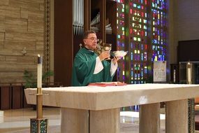 priest with a cup at the altar