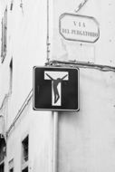 sign with a crucifix on a wall in florence