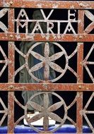 Ave Maria, wrought iron lettering on aged grates