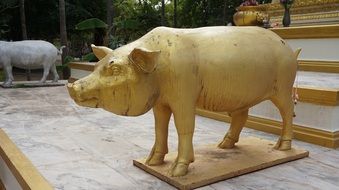 golden statue of a pig in a temple in thailand