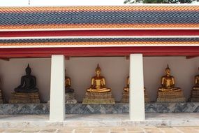 many golden statues of buddhas in a temple in bangkok