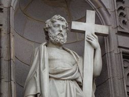 statue of a saint with a cross on the church