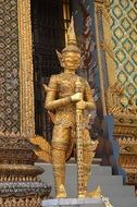 golden statue of the devil near the temple