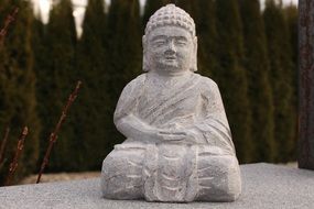Stone sculpture of Buddha near the trees