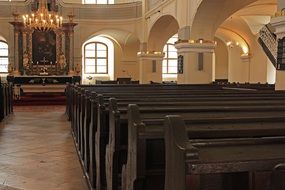 wooden benches in front of the altar in the church