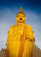 golden buddha statue on a street in thailand