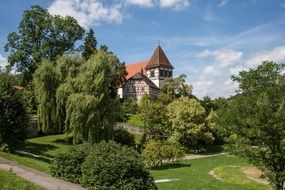 distant view of a church among green trees in germany