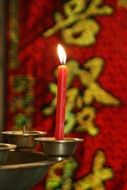 red candle in buddhist temple close up