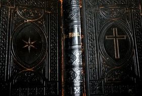 cross on the dark cover of a bible